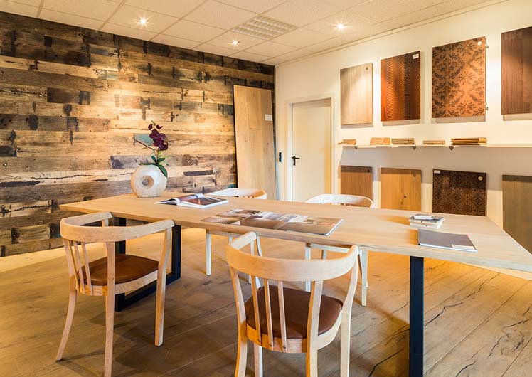 Showroom von Parkettfarm in Würselen, Aachen, mit Holztisch und Parkettmuster an der Wand.